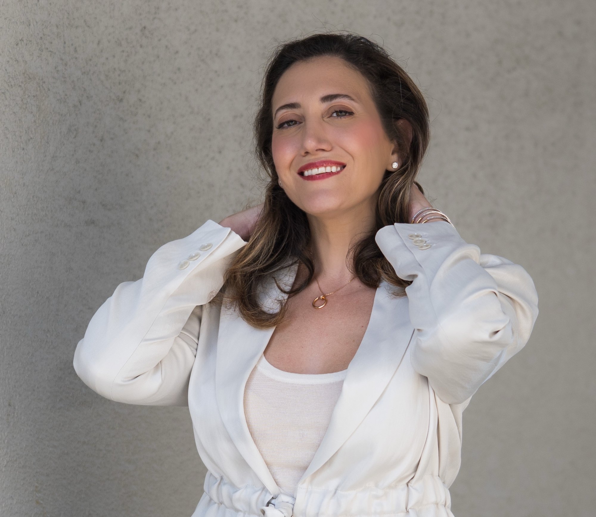 Yasaman Nazhand, certified integrative women's health coach, smiling in a cream blazer